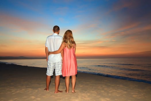 Couple on the beach at sunrise time.