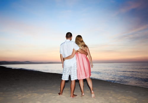 Couple walking on the beach at sunrise time.