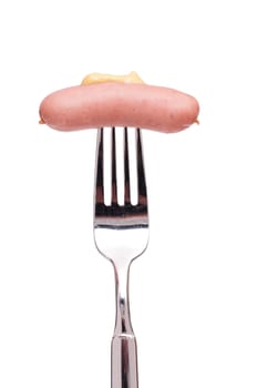 A white cut-out small string sausage with mustard on a fork