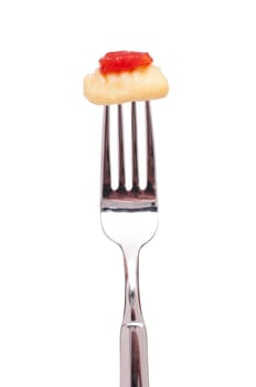 White isolated gnocchi and tomato on a fork