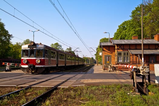 Passenger train passing the railroad crossing with the road