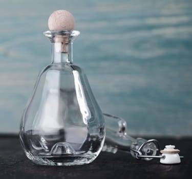 Decorative empty conical glass decanter with a round wooden stopper