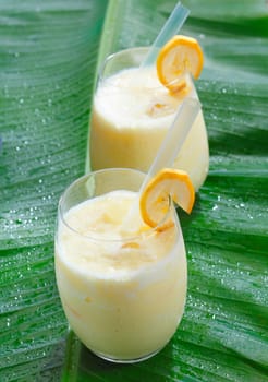 High angle view of two glasses of fruity banana smoothie blended with creamy yoghurt and garnished with banana slices