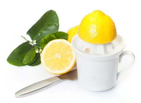 Preparing fresh lemon juice for use as an ingredient in cooking with a halved lemon on a plastic juicer
