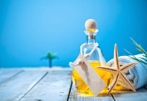 Wellness and rejuvenation with a decanter of golden aromatherapy oil with blank lable on a deck at the seaside
