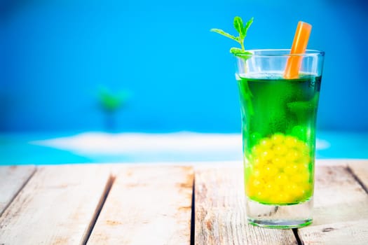 Bubble tea at the beach. Standing on a wooden deck near the strand with copyspace.