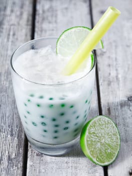 Fresh tapioka pearls tea with lime sirup standing on a wooden plate