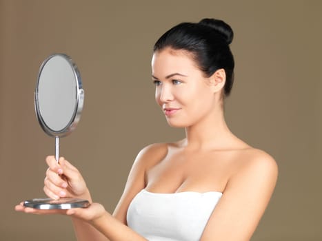 Portrait of beautiful woman, she is looking at the mirror