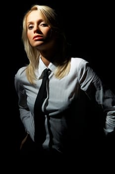 Blond model, business woman pose on black background