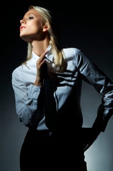 Blond model, business woman pose on black background
