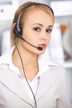 Blond business woman working in office, wearing headset