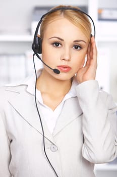 Blond business woman working in office, wearing headset
