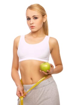 Sporty beautiful girl is measuring her waist on white