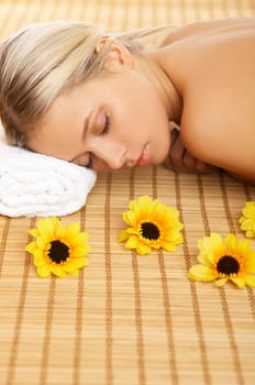 Portrait of Beautiful woman laying on bamboo mat around yellow flowers