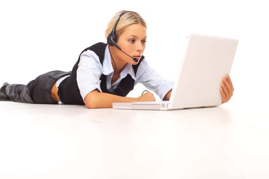 Businesswoman working on her laptop while lying down on the floor