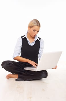 Businesswoman working on her laptop while sitting on the floor