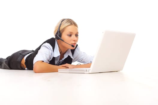 Businesswoman working on her laptop while lying down on the floor