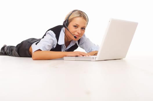 Businesswoman working on her laptop while lying down on the floor
