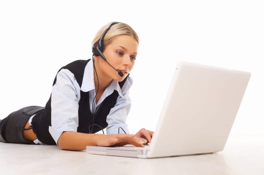 Businesswoman working on her laptop while lying down on the floor