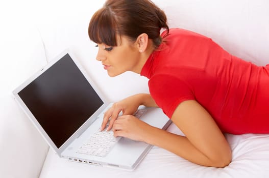 Young pretty women on white couch relaxing and using laptop computer