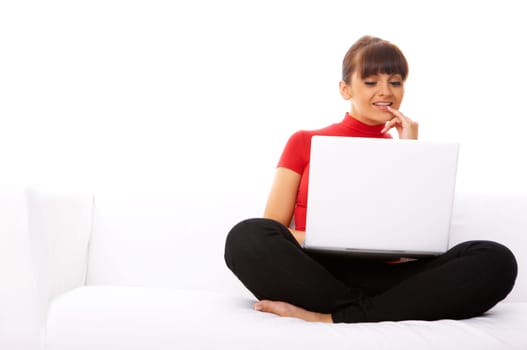 Young pretty women on white couch relaxing and using laptop computer