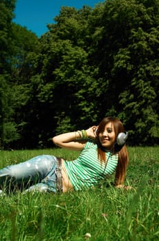 Beautiful asian young girl with headphones, listen to music on meadow