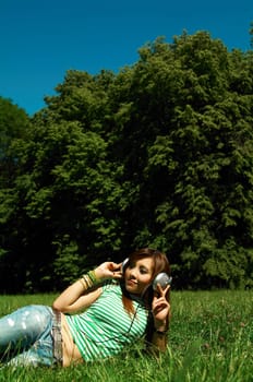 Beautiful asian young girl with headphones, listen to music on meadow