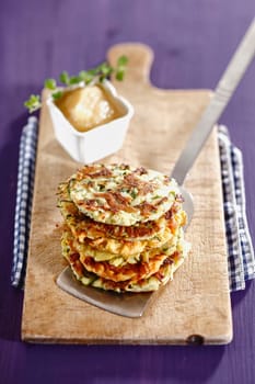 Potato Fritters with apple sauce on a wooden plate