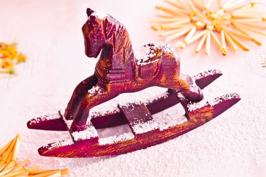 Christmas red miniature rocking horse sprinkled with powdered sugar to resemble snow.