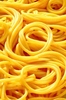 Closeup of freshly boiled spaghetti coiled in random patterns for an interesting background.