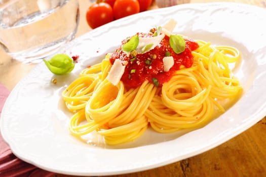 Plate of freshly prepared spaghetti bolognaise with a tomato sauce and cheese ready to be served.