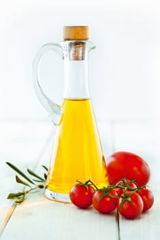 Ingredients for Italian Food, olive oil, tomatoes, fresh basil and herbs for seasoning, standing on a wooden background