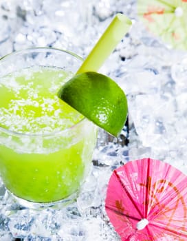 Fresh delicious lime smoothie on a bed of crushed ice with a cocktail umbrella