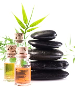 Massage oils and basalt stones necessary for a hot rock treatment in a spa setting