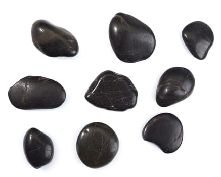 Collection of black massage stones as used in a spa hot rock pampering treatment isolated on white