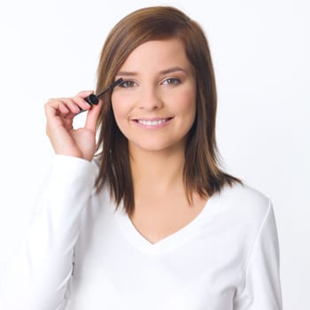 Portrait of beautiful young woman is doing her makeup