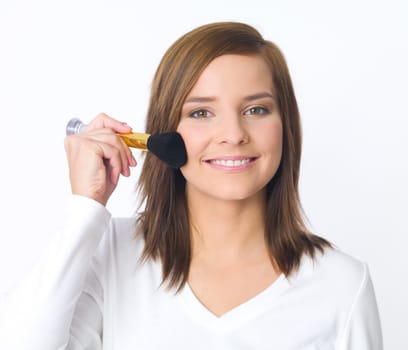 Portrait of beautiful young woman is doing her makeup