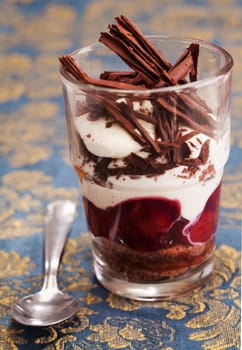 Delicious chocolate parfait dessert topped with thick whipped cream and flaked chocolate