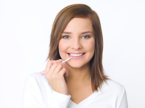 Portrait of beautiful young woman is doing her makeup