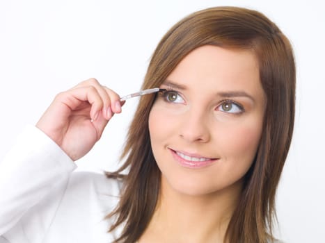 Portrait of beautiful young woman is doing her makeup