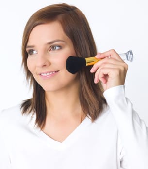 Portrait of beautiful young woman is doing her makeup