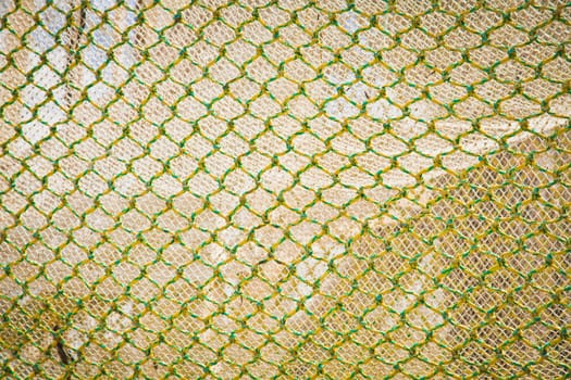 Abstract background of openframe knotted yellow green netting used by trawlers as a trawlnet when deep sea fishing
