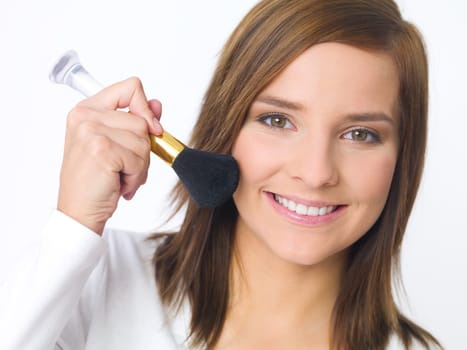 Portrait of beautiful young woman is doing her makeup