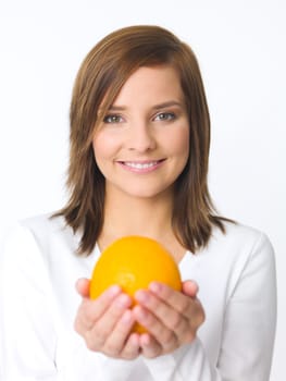 Portrait of beautiful young woman holding fresh orange fruit