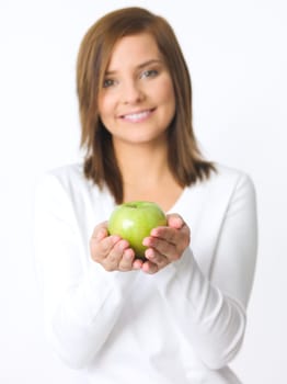Portrait of beautiful young woman holding green apple