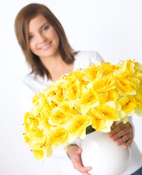 Portrait of beautiful young woman holding vase of flowers