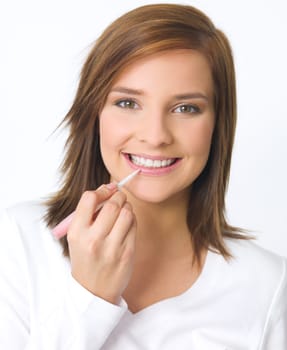 Portrait of beautiful young woman is doing her makeup