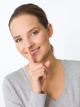 Portrait of beautiful young woman showing quiet gesture