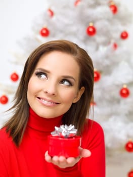 Beautiful woman next to christmas tree wearing red sweater