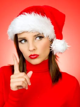 Portrait of beautiful woman wearing santa claus hat on red background